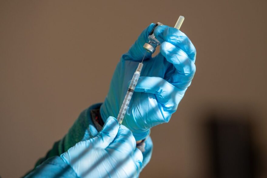 A health care worker fills a syringe with the Pfizer COVID-19 vaccine at Connecticut's largest drive-thru vaccination clinic administered by Community Health Center, Inc.