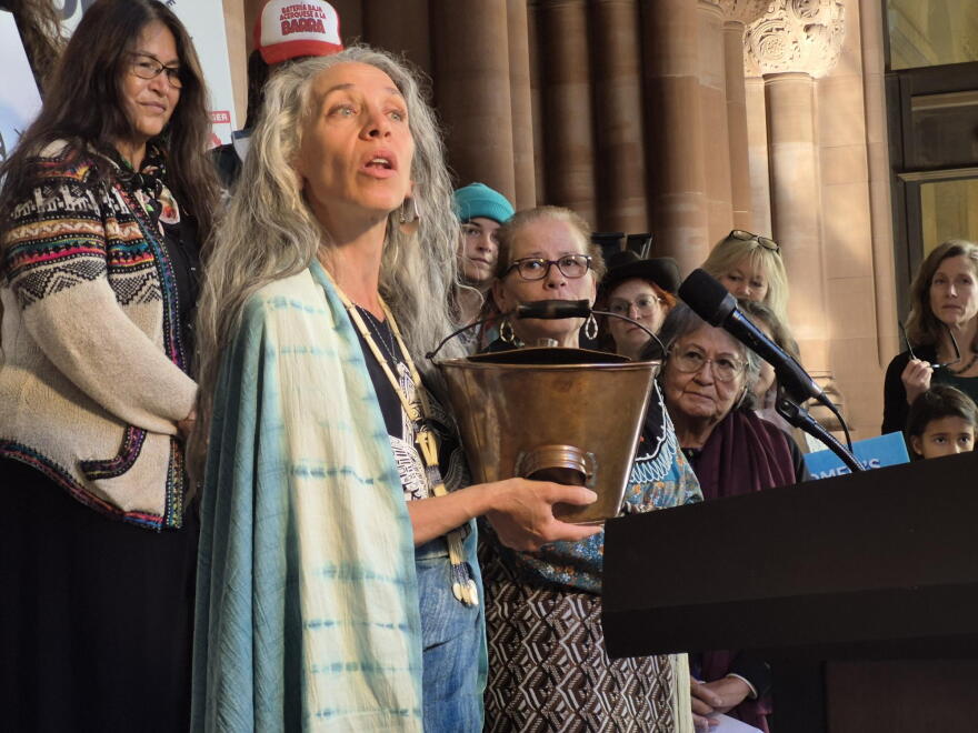 Bethany Yarrow, an organizer of the Women's Water Walk, holds a bucket of water collected along the route while speaking at the New York State Capitol on Oct. 6, 2026.