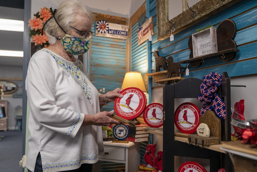 Pat Hoeffken, one of the partners of Makers Market in Maryville, shows one of her crafts, a large cardinals themed wood token on May 29. The store opened to customers for the first time on Friday. 05 29 2020