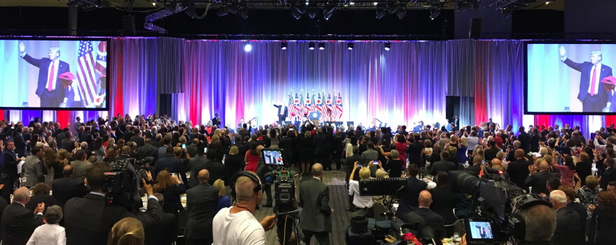 President Donald Trump leaves the stage as the crowd applauds. 