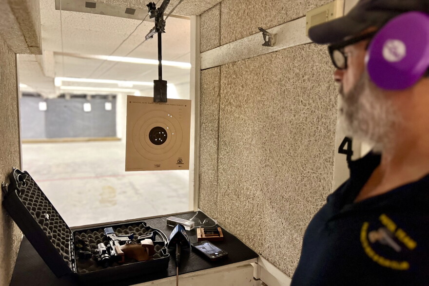 Carl Simons, a member of the Falmouth Rod & Gun Club, reviews a target at the club's indoor shooting range.