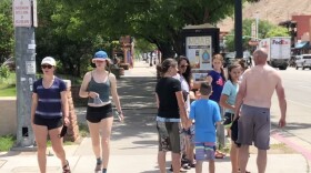 A group of people standing on the sidewalk.