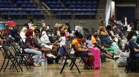 People wait to board buses Tuesday in Lake Charles, La., as they prepare to be evacuated before Hurricane Laura's arrival.