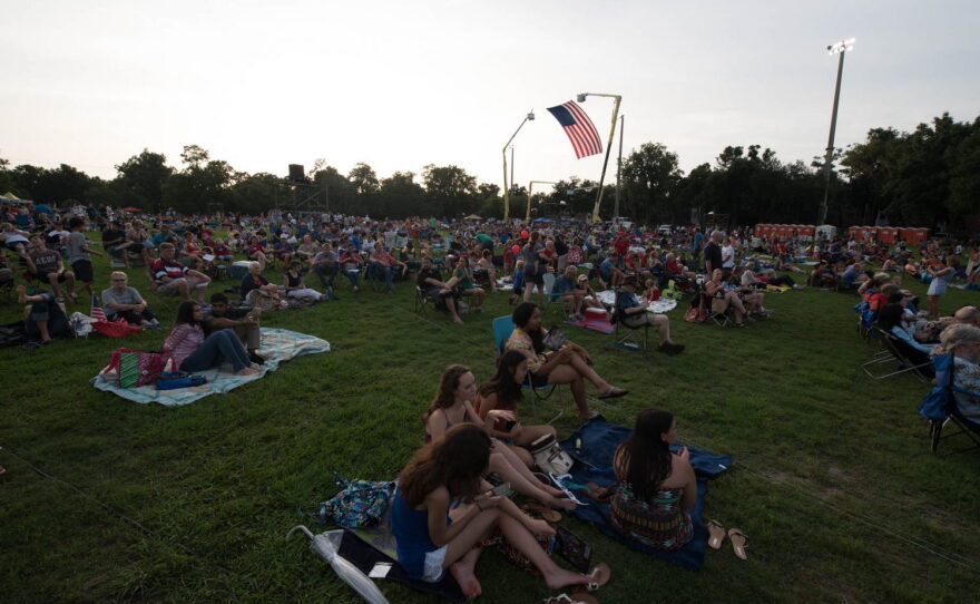 Our partners GRU brought their giant flag and suspended it from two bucket loaders once again this year. (Photo by Steve Johnson/WUFT News)