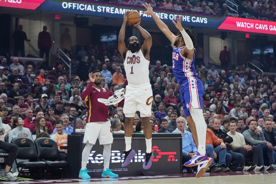 Cleveland Cavaliers guard James Harden (1) shoots as Philadelphia 76ers forward Trendon Watford (12) defends and teammate Donovan Mitchell, left, looks on in the first half of an NBA basketball game in Cleveland, Monday, March 9, 2026. 