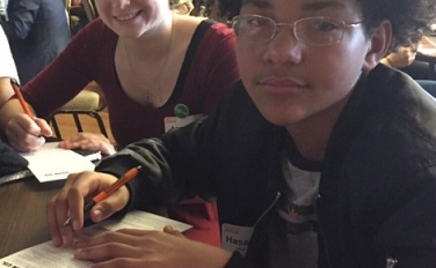 Two students sign pledge cards at Humanity Summit