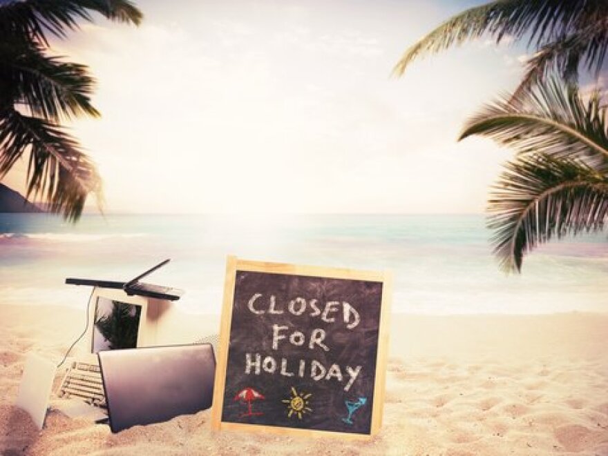 A Closed for Holiday sign on the beach