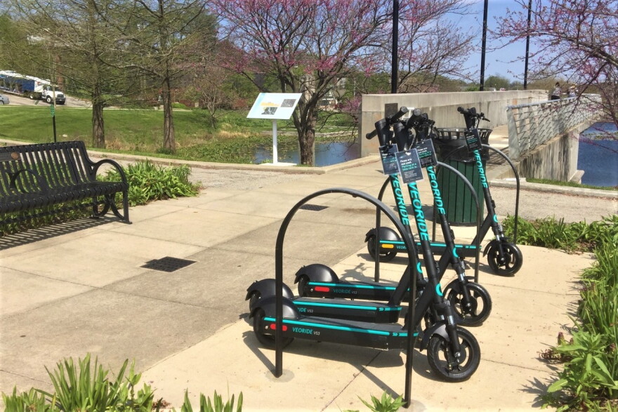 VeoRide scooters lined up near a bike rack in Bloomington.