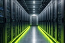 A room full of servers. The camera is positioned directly in front of a hallway, servers are stacked on each side. They are lit from below with green light. 