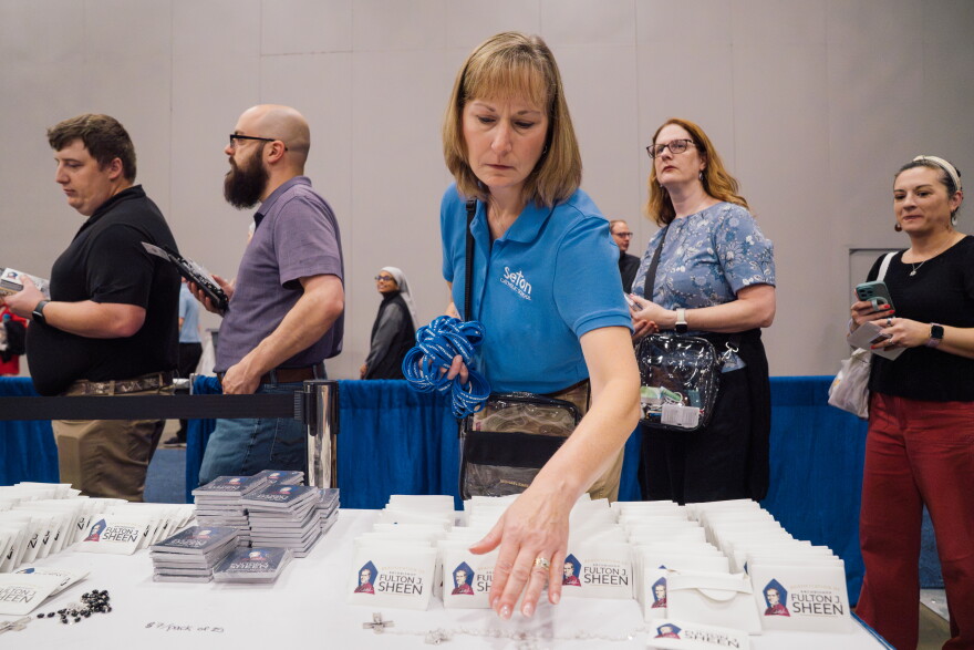 Michelle Melin, a fifth-grade teacher at Seton Catholic School in Moline, Ill., adjusts rosaries ahead of the beatification Mass for the late Archbishop Fulton J. Sheen on Thursday in downtown St. Louis.
