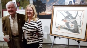 Artist John Ruthven and Great Parks Chief Operating Officer Rebecca McDonough pose for a picture beside his painting of "Martha," the famous last passenger pigeon. 