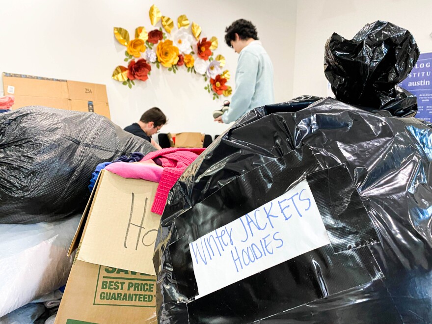 Two boys sort through donated clothing for earthquake victims in Turkey.