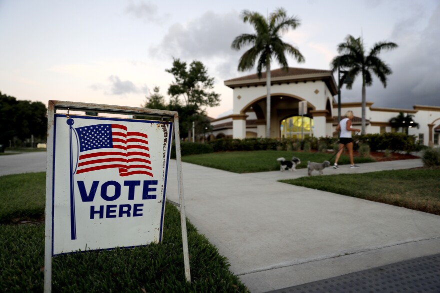 A sign is placed outside of a polling place at the Boca Raton Library during the Florida primary election, Tuesday, March 17, 2020, in Boca Raton, Fla.  As Florida officials try to contain the spread of the novel coronavirus, the state's voters will head to the polls and cast ballots in the Democratic presidential primary. 