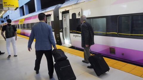 Passengers walk to board a Brightline train in Miami. Brightline first began running its trains between Miami and Orlando in 2023. The company began running its neon-yellow trains between Miami and West Palm Beach in 2018.