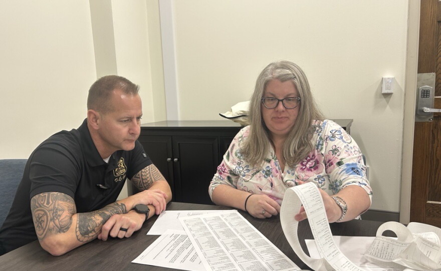 Saginaw police officer Matt Gerow and the city's lawyer Amy Lusk examine the results of the voter tabulation test on Tuesday, Oct. 13, 2026.