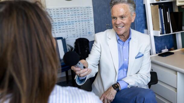 John Costello, Director of the Augmentative Communication Program, talks with a visitor at his office at Boston Children's Hospital in Waltham.  (Robin Lubbock/WBUR)