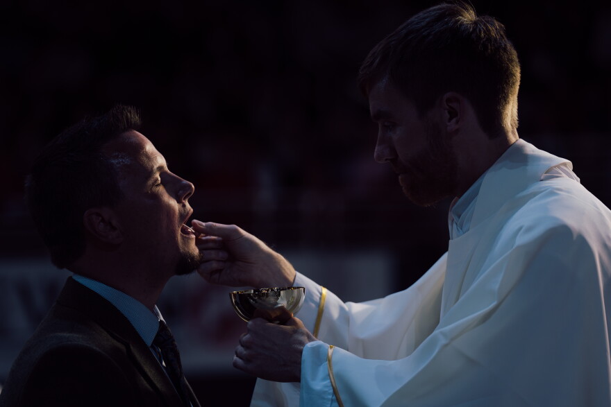 A priest distributes Communion during the beatification Mass for the late Archbishop Fulton J. Sheen on Thursday at the Dome at America's Center in downtown St. Louis.