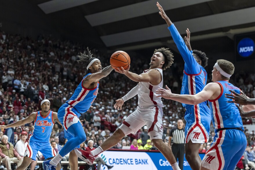 Alabama guard Mark Sears, center, works between Mississippi guard Dre Davis, left, and forward Malik Dia, right, during the second half of an NCAA college basketball game, Tuesday, Jan. 14, 2025, in Tuscaloosa, Ala. (AP Photo/Vasha Hunt)