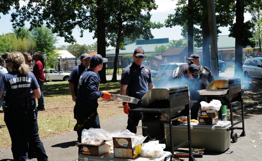Members of Norfolk Fire-Rescue prepare barbecue during the Community Service Board’s Mental Health Matters Community Event on May 15.