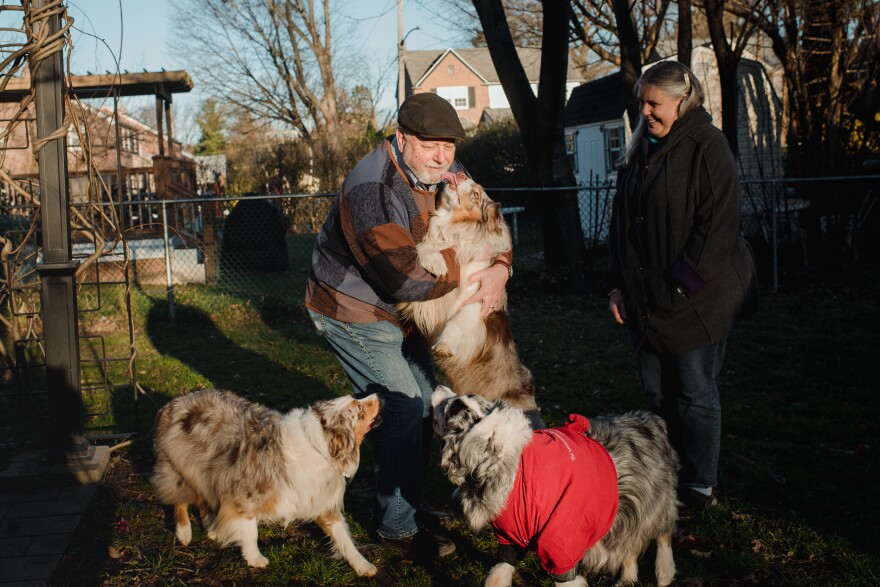 Nick and Debi Lemieur play with their dogs in their backyard. The Lemieurs instated a weekly budget review 14 years ago to account for all of their expenses.
