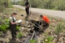 The Eastern Pennsylvania Coalition for Abandoned Mine Reclamation (EPCAMR) documents the height of a culvert on Shickshinny Creek in Union Township, Luzerne County as part of water conservation work. From left to right: Morgan Romanowski, Ian Padden and Robert “Bobby” Hughes.