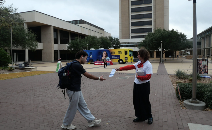 Clare Carter of PEN America handing out copies of Plato's Symposium to Texas A&M students.