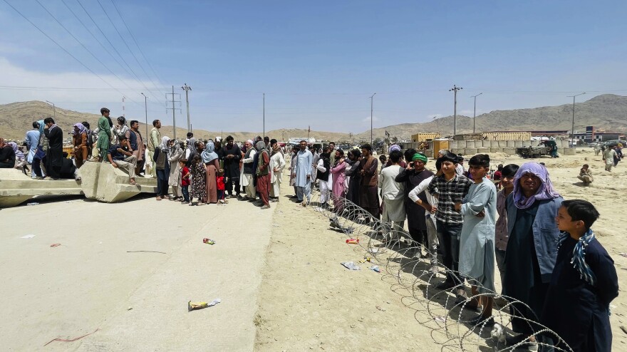 Throngs gather outside the international airport in Kabul on Tuesday.