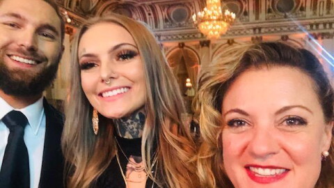 Three people smile into the camera 