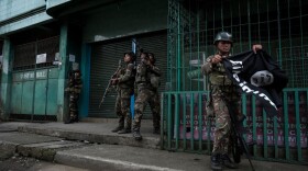 A soldier carrying a captured ISIS flag while clearing a city street of militants on May 26, 2017 in Marawi city, southern Philippines. (Jes Aznar/Getty Images)