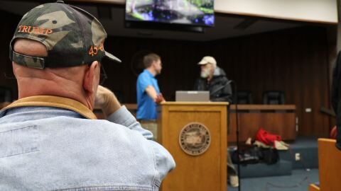 An audience member watches Troy Roberts, the communication and outreach manager for the Suwannee River Water Management District, and John. S. Quarterman, with the Suwannee Riverkeeper at WWALS Watershed Coalition, speak before the meeting on Feb. 5, 2026.