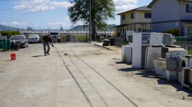 A Pajaro resident cleans up his street after floods in March 2023 devastated the community.