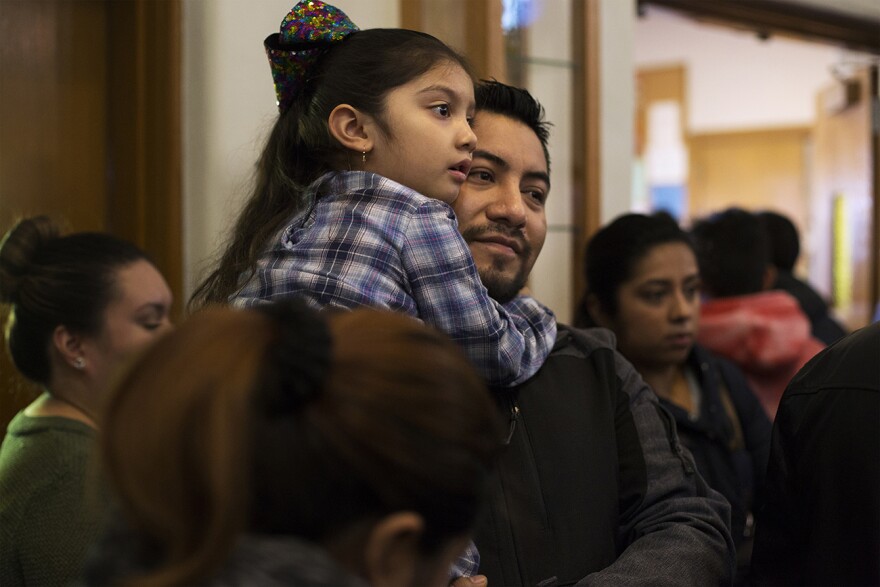 Garcia holds Amanda, 5, as she looks for her sisters after Sunday Mass. Nov. 19, 2017