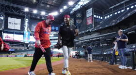 Philadelphia Phillies manager Rob Thomson, left, talks with Phillies Johan Rojas after a short workout session. The Phillies played Game 3 against the Arizona Diamondbacks in the baseball NL Championship Series on Thursday. (Ross D. Franklin/AP)
