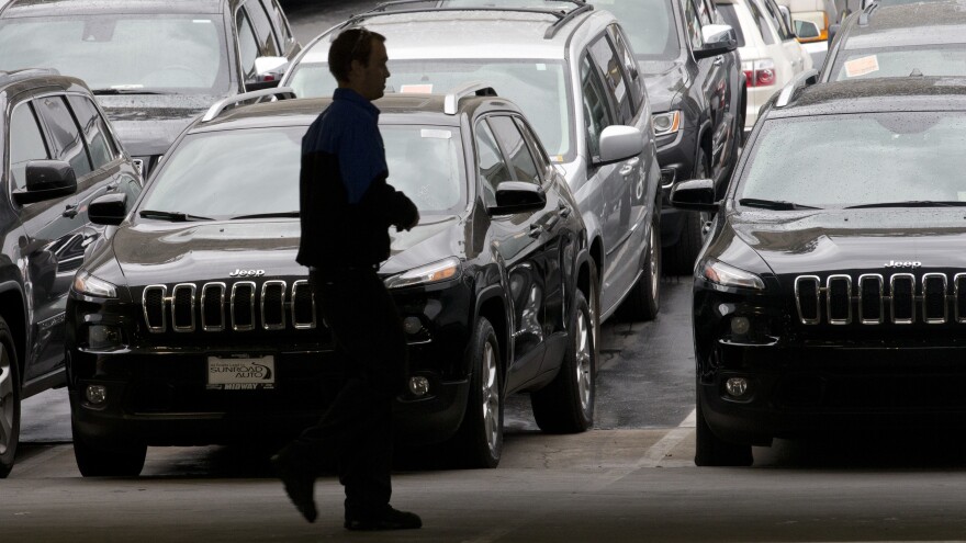 A worker on a Chrysler car lot passes lines of Jeeps in 2014. The House on Tuesday passed a measure to roll back guidance on auto lending issued by the Consumer Financial Protection Bureau.