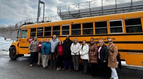 Chicopee School Superintendent Dr. Marcus Ware stands with school department and transportation employees as well as Chicopee Treasurer Marie LaFlamme to highlight new bus stop arm safety program.