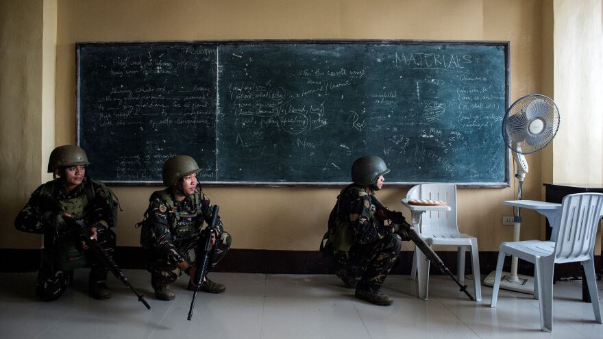 Philippine army Scout Rangers crouch in a classroom during a mission to flush out militant snipers in Marawi on Tuesday. Using these snipers, human shields and their knowledge of the city, the ISIS-linked militants have continued to maintain their grasp on parts of the city.