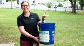 Charlotte city arborist Laurie Reid holds up her tree-watering bucket.