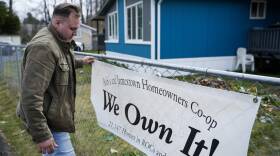 Gadiel Galvez, 22, adjusts a sign stating that his resident cooperative owns their mobile home park. (Lindsey Wasson/AP)