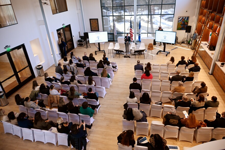 Audience members at the HMTX House in Norwalk view the unveiling of of KidSafeHQ, which has a list of FAQ's on learning and addressing the signs of child sexual exploitation, digital safety, and multilingual conversation guides among others, at the HMTX House in Norwalk on February 27, 2026.