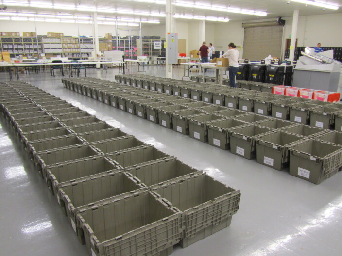 Dozens of empty ballot boxes are lined up on the floor of a big building as Ada County prepares for the 2012 Primary Election.