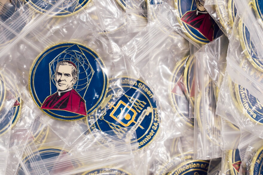 Commemorative coins depicting the late Archbishop Fulton J. Sheen are offered for sale ahead of his beatification Mass on Thursday.