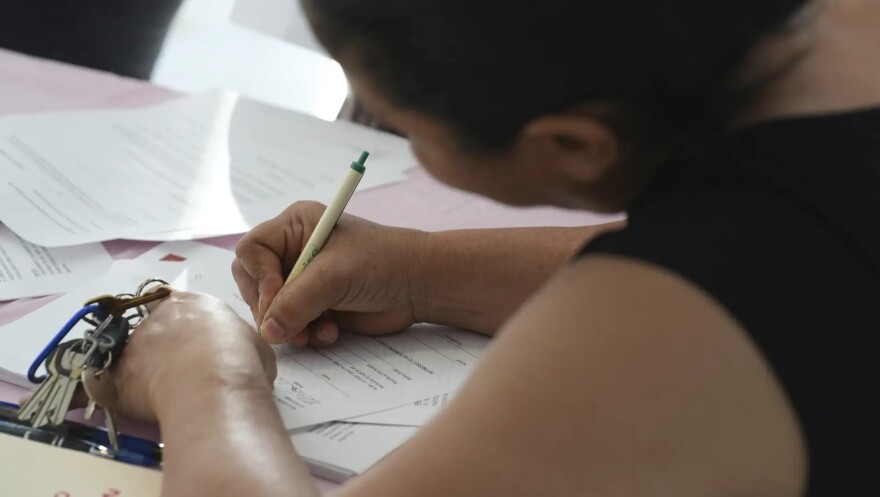 A young mother signs a document to give someone else legal guardianship of her minor children if she is detained or deported by immigration authorities in this January 2025 file photo taken in Miami.