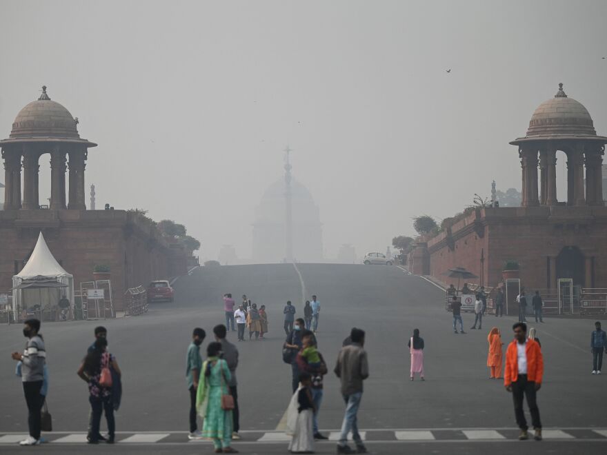 Visitors walk along the Raisina Hills at Rajpath amid smoggy conditions in New Delhi on Thursday.