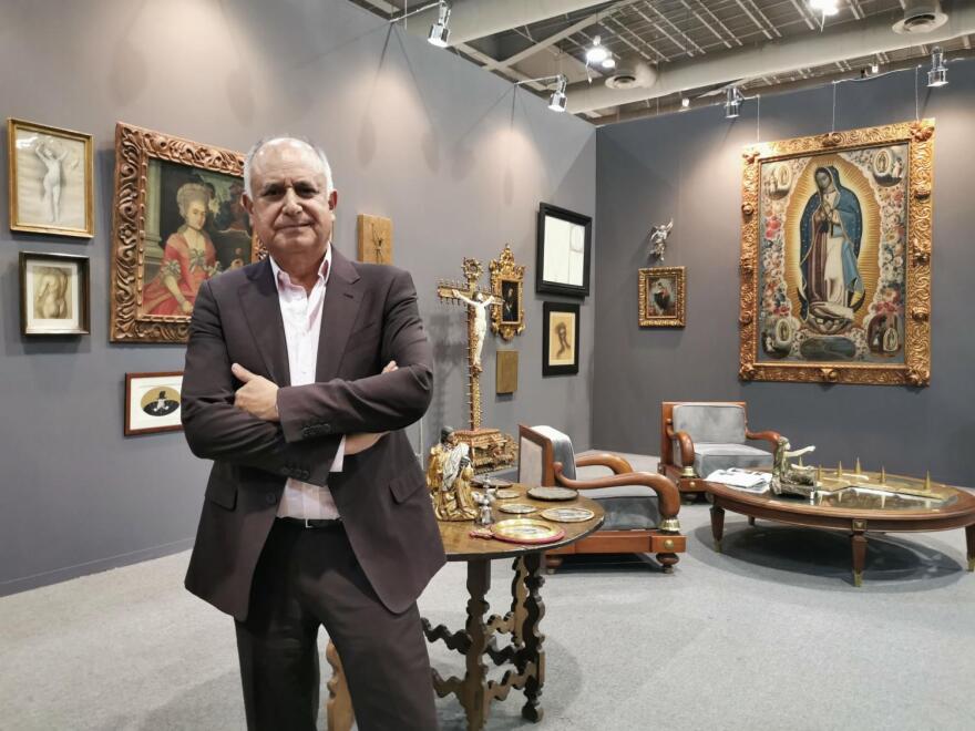 Mario Uvence displaying his gallery's collection of antiques and fine arts.