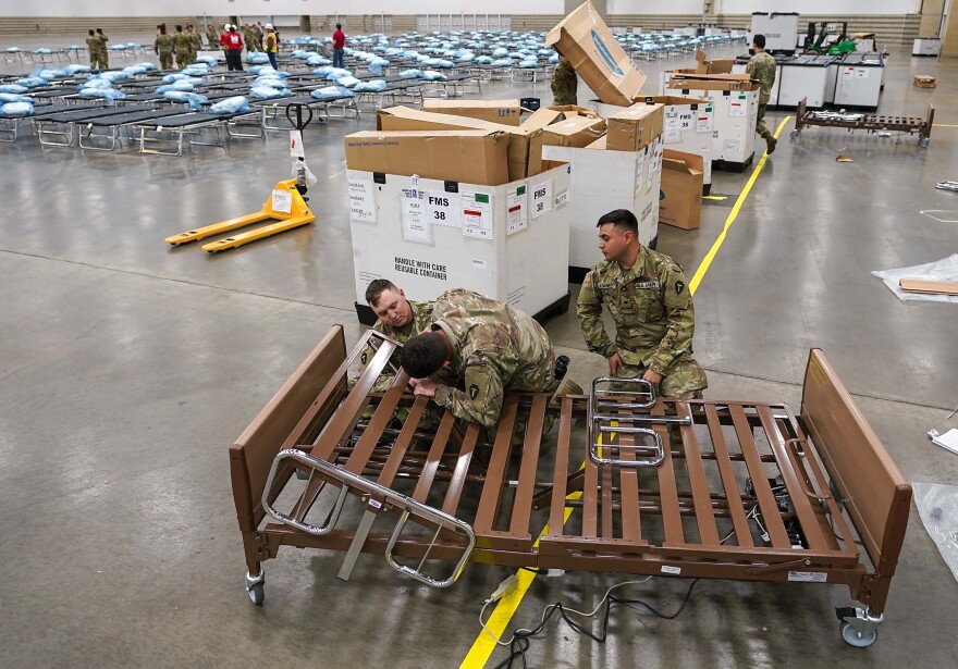 Texas Army National Guardsmen put together a hospital bed as they set up a field hospital in response to the new coronavirus crisis at the Kay Bailey Hutchison Convention Center on Tuesday, March 31, 2020, in Dallas. 