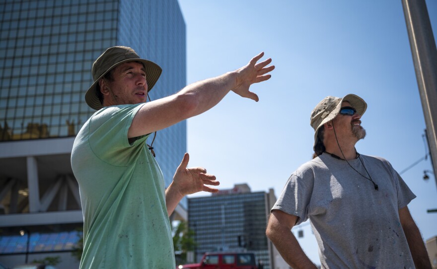 Artists Michael Rice (left) and Chris Gann (right) step back to look at the mural they are spray painting on the side of the 18-story Millennium Apartments building at 50 Morgan Street in Hartford. The mural is estimated to be one of, if not the tallest, mural between New York and Boston.