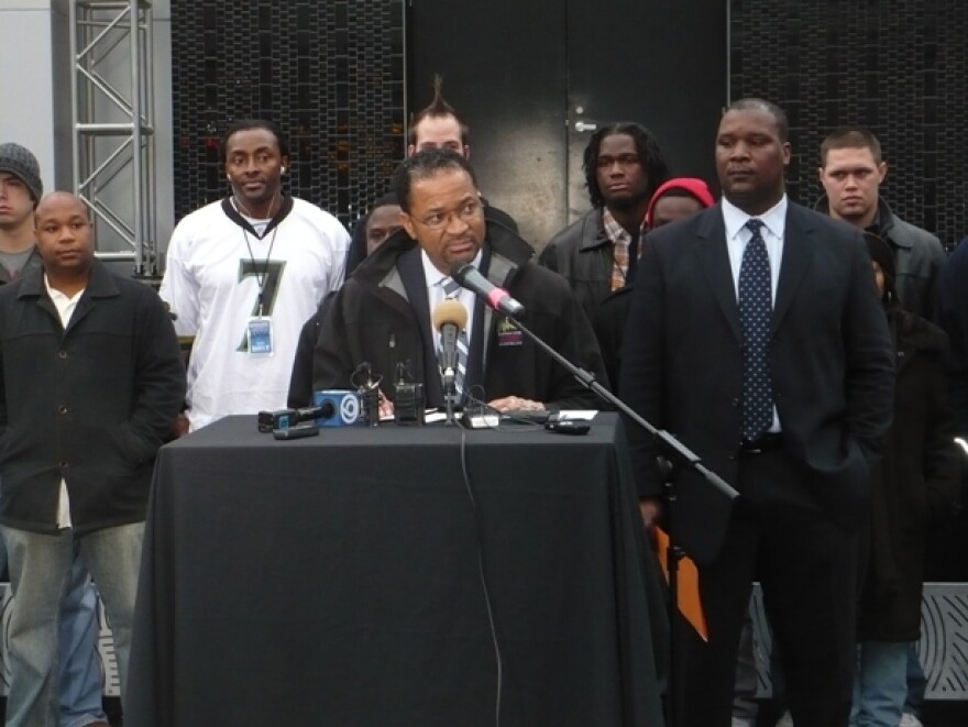 Cordish representative Zed Smith and Power & Light District director Kevin Battle announce plans for new board, alongside many of the entertainment district's current bouncers. Photo by Tim Bridgham / KCUR.