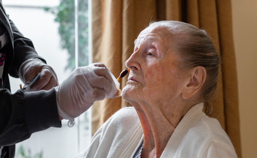 Licensed vocational nurse Joana Bartolome swabs Shinkle's nose with an antibacterial, iodine-based solution at Anaheim's Coventry Court Health Center. Studies find patients can harbor drug-resistant strains in the nose that haven't yet made them sick.