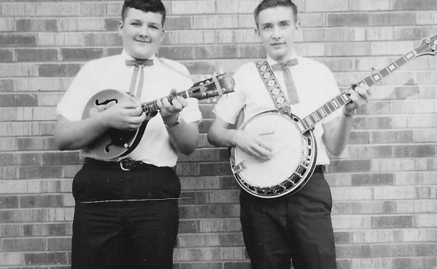 photo of two boys in the teens holding a mandolin and banjo