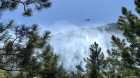 A helicopter drops water on the Beeskove fire north of Missoula July 26, 2019.